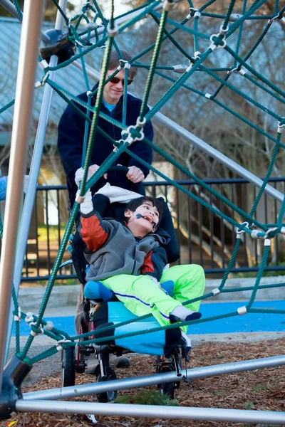 Père avec garçon handicapé à l'aire de jeux — Photo