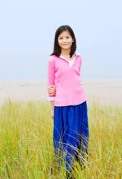 Ragazza in piedi in alto campo erboso — Foto Stock