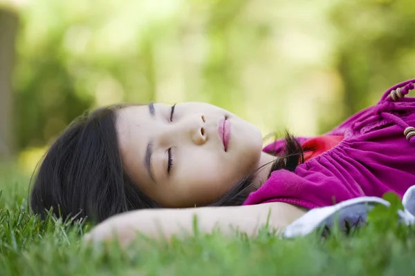 Petite fille couchée sur l'herbe — Photo