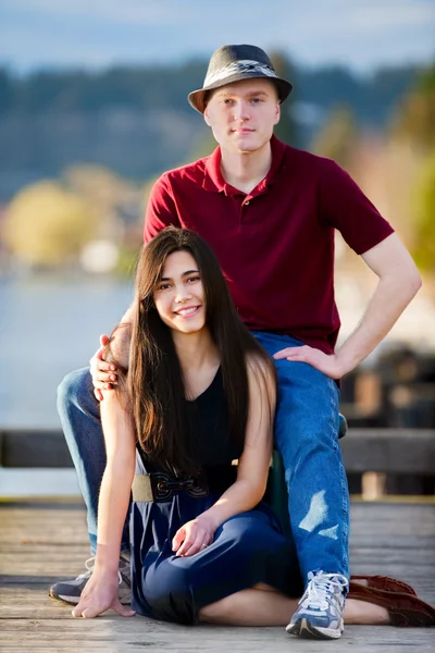 Jovem interracial casal sentado juntos no doca sobre lago — Fotografia de Stock