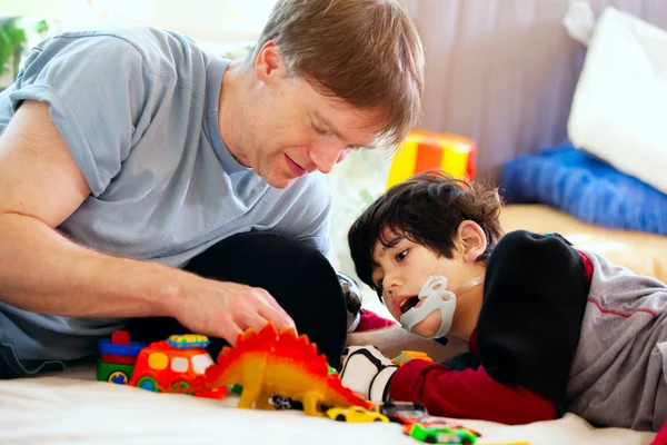 Schöner Vater spielt mit behindertem Sohn Autos — Stockfoto