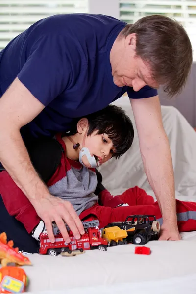 Schöner Vater spielt mit behindertem Sohn Autos — Stockfoto