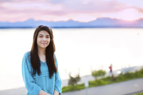 Piękna młoda dziewczyna nastolatka ciesząc się na zewnątrz przez jezioro o zachodzie słońca — Zdjęcie stockowe