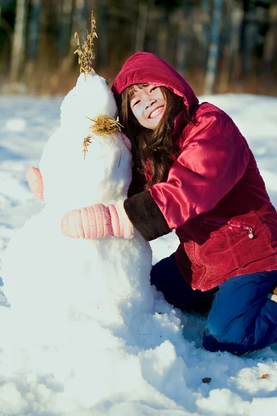 Young girl in red jacket playing outdoors in snow — Stock Photo, Image