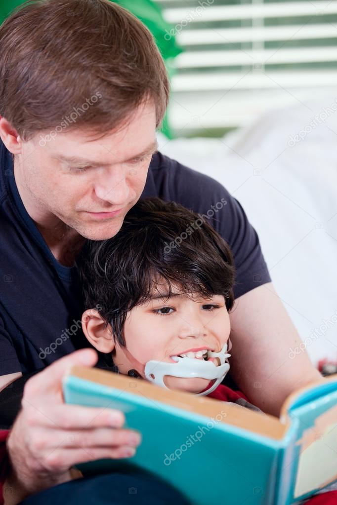 Father reading book to disabled little son