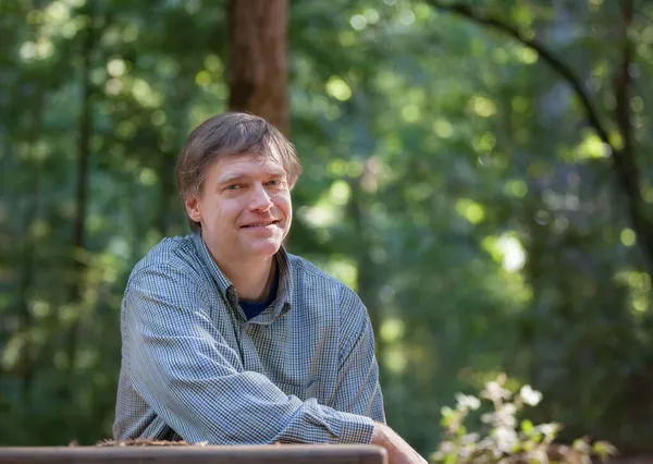 Lächelnder Kaukasischer Mann Anfang Fünfzig Der Allein Hölzernen Picknicktisch Wald — Stockfoto