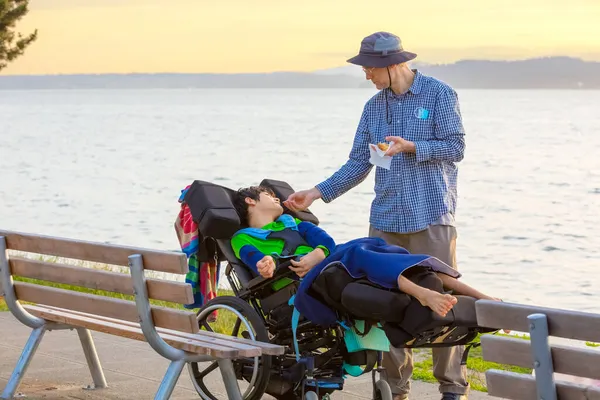 Père Caucasien Nourrir Hamburger Pour Handicapés Biracial Jeune Garçon Fauteuil — Photo