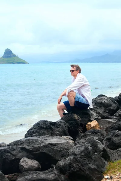 Stilig Kaukasiska Man Fyrtioårsåldern Sitter Steniga Stranden Hawaiian Stranden Kiness Stockbild