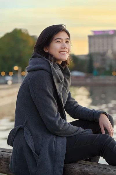 Smiling Teen Girl Young Adult Female Gray Jacket Sitting Outdoors Royaltyfria Stockbilder