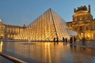 Paris, Fransa - 18 Kasım 2021: Louvre Müzesi Piramitli Gece Manzarası. Burası Fransa 'nın en popüler seyahat merkezlerinden biri ve Paris' in merkezi bir simgesidir..