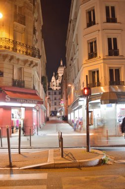 Paris, Fransa - 12 Kasım 2021: Montmartre 'nin eski sokaklarının Basilique du Sacre-Coeur ile gece manzarası.