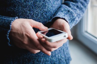 Adam akıllı bir telefon kullanıyor. Modern cep telefonu elinde..