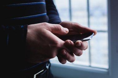 Adam akıllı bir telefon kullanıyor. Modern cep telefonu elinde..