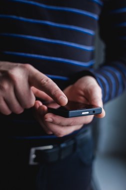 Adam akıllı bir telefon kullanıyor. Modern cep telefonu elinde..