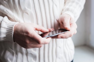 Adam akıllı bir telefon kullanıyor. Modern cep telefonu elinde..