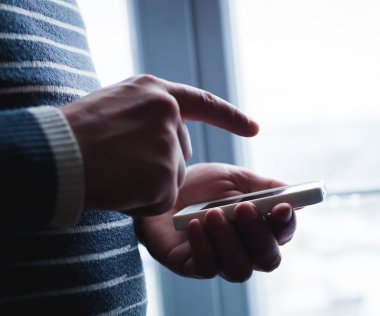 Adam akıllı bir telefon kullanıyor. Modern cep telefonu elinde..