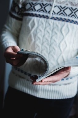 bir adam bir dergide görünüyor. basın eller.