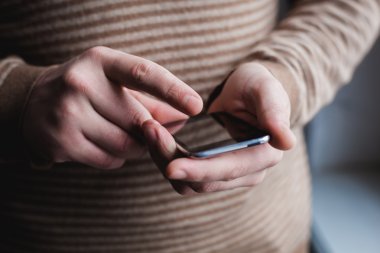 Adam akıllı bir telefon kullanıyor. Modern cep telefonu elinde..