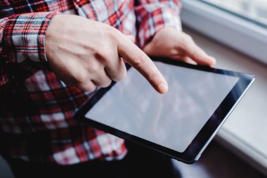 Adam tablet bilgisayar kullanıyor. Elinde modern bir alet..