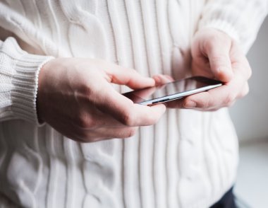 Adam akıllı bir telefon kullanıyor. Modern cep telefonu elinde..