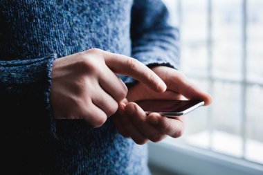Adam akıllı bir telefon kullanıyor. Modern cep telefonu elinde..