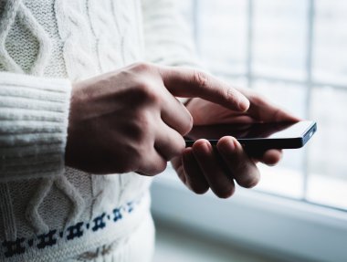 Adam akıllı bir telefon kullanıyor. Modern cep telefonu elinde..