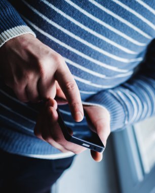 Adam akıllı bir telefon kullanıyor. Modern cep telefonu elinde..