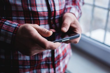 Adam akıllı bir telefon kullanıyor. Modern cep telefonu elinde..