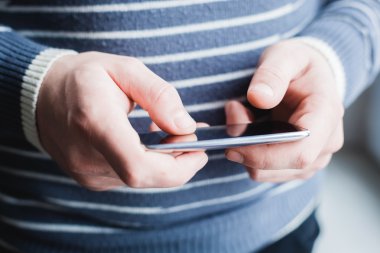 Adam akıllı bir telefon kullanıyor. Modern cep telefonu elinde..