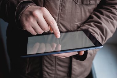 Adam tablet bilgisayar kullanıyor. Elinde modern bir alet..