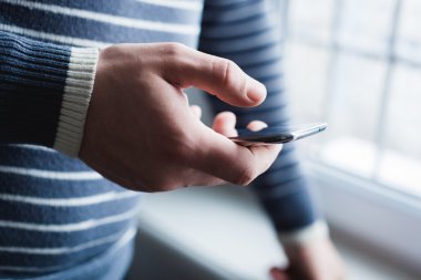 Adam akıllı bir telefon kullanıyor. Modern cep telefonu elinde..