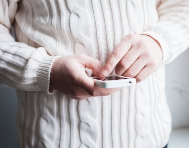 Adam akıllı bir telefon kullanıyor. Modern cep telefonu elinde..