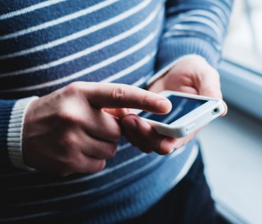 Adam akıllı bir telefon kullanıyor. Modern cep telefonu elinde..