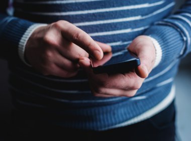 Adam akıllı bir telefon kullanıyor. Modern cep telefonu elinde..