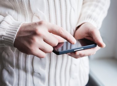 Adam akıllı bir telefon kullanıyor. Modern cep telefonu elinde..
