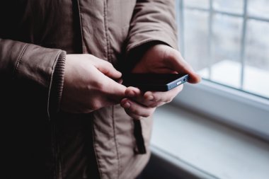 Adam akıllı bir telefon kullanıyor. Modern cep telefonu elinde..