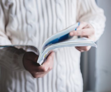 bir adam bir dergide görünüyor. basın eller.