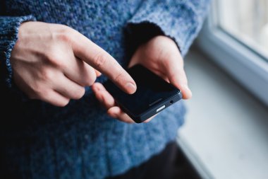 Adam akıllı bir telefon kullanıyor. Modern cep telefonu elinde..