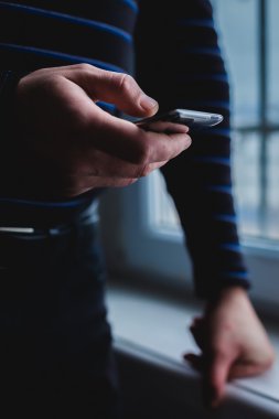 Adam akıllı bir telefon kullanıyor. Modern cep telefonu elinde..