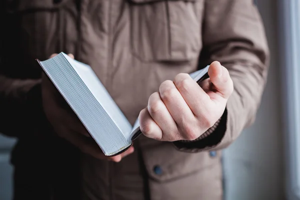 Un homme qui lit. Livre dans ses mains . — Photo