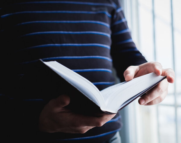 Man reading. Book in his hands.