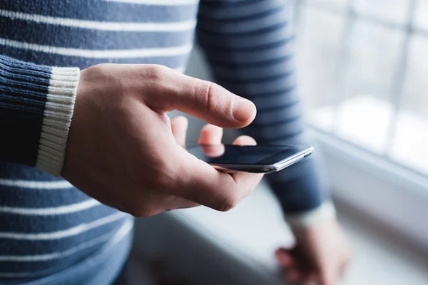 The man is using a smartphone. Modern mobile phone in hand. — Stock Photo, Image