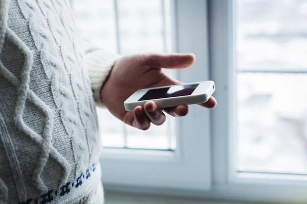 Han använder en smartphone. Modern mobiltelefon i handen. — Stockfoto