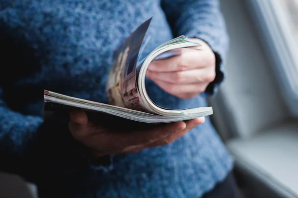 Un hombre mira una revista. Presione las manos . — Foto de Stock