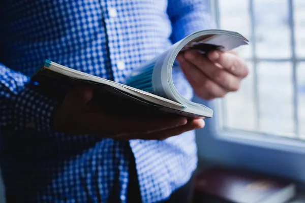 A man looks at a magazine. Press hands. — Stock Photo, Image