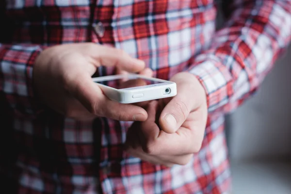 The man is using a smartphone. Modern mobile phone in hand. — Stock Photo, Image