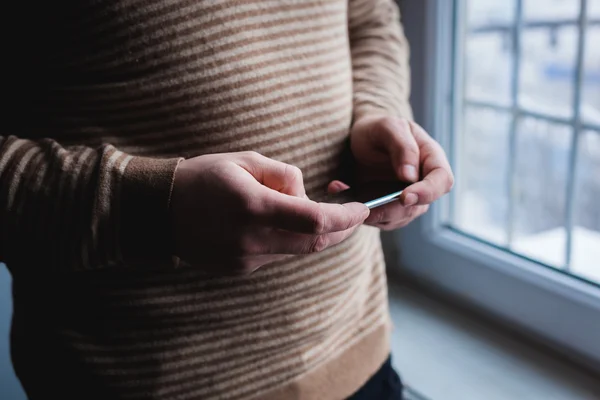 El hombre está usando un teléfono inteligente. Teléfono móvil moderno en la mano . — Foto de Stock