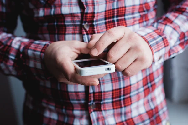 O homem está usando um smartphone. Telemóvel moderno na mão . — Fotografia de Stock