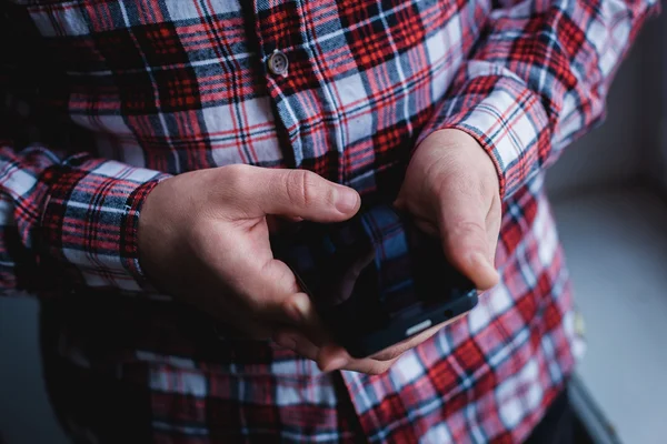 El hombre está usando un teléfono inteligente. Teléfono móvil moderno en la mano . — Foto de Stock