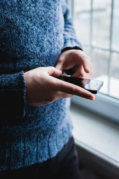 O homem está usando um smartphone. Telemóvel moderno na mão . — Fotografia de Stock